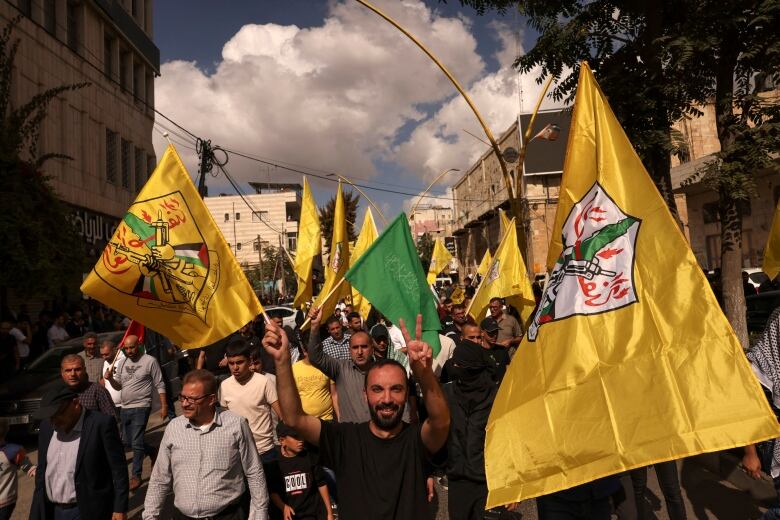 Several people are shown marching carrying flags.