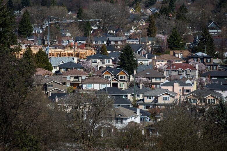 A condo building is seen under construction surrounded by houses in Vancouver, B.C.