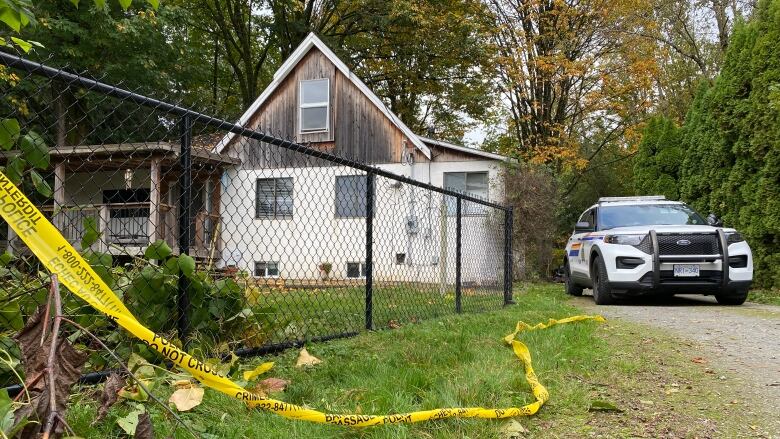 A police vehicle and police tape outside a home