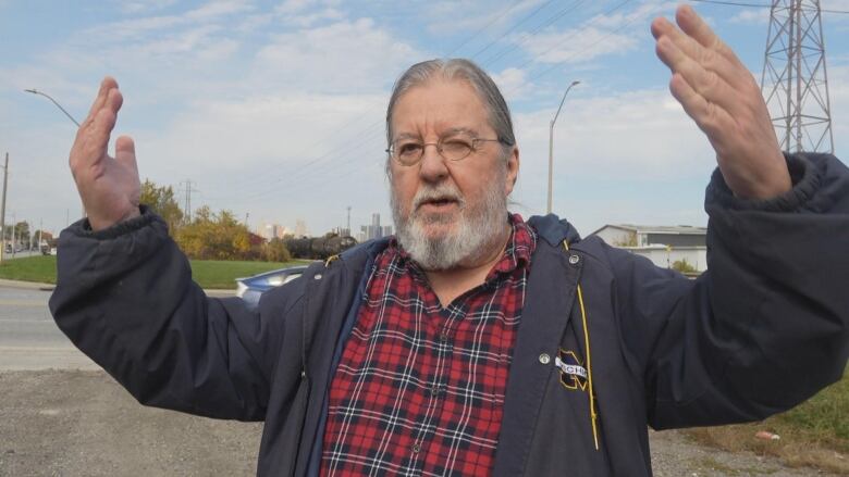 A man holds his hands up in the air in frustration. 