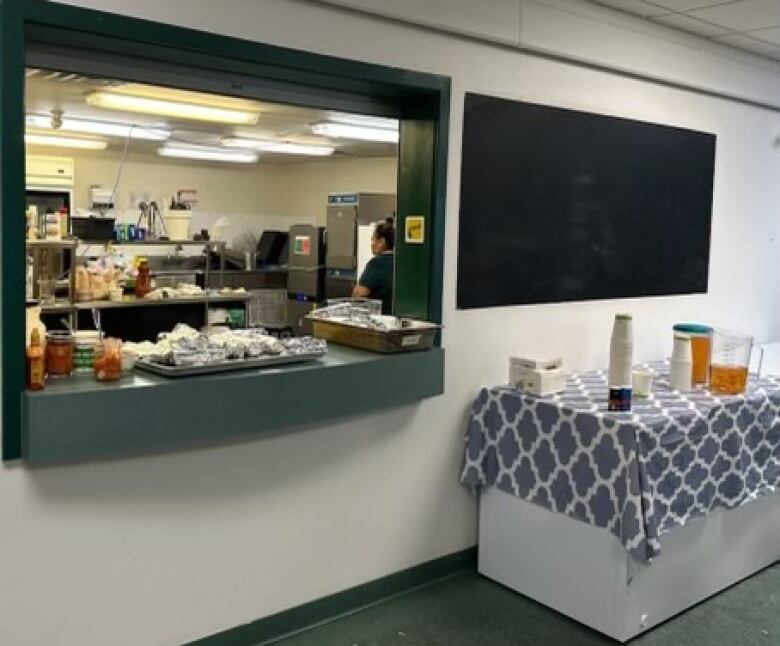 A concession at a public building is seen, with a window looking into the kitchen.