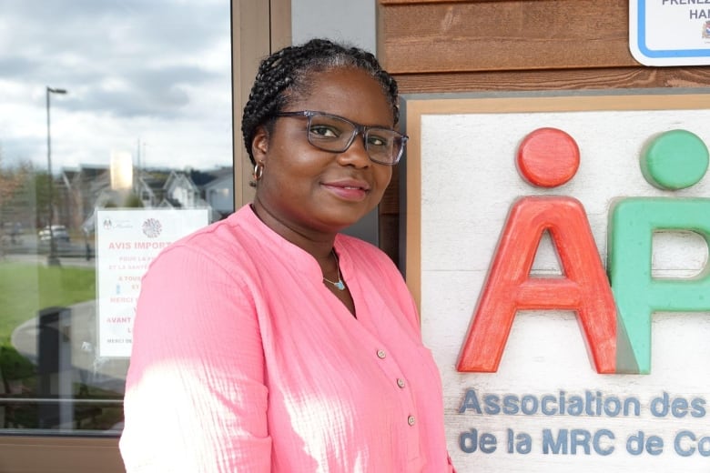 A woman is seen in front of a building.