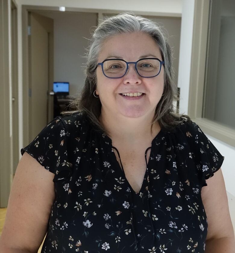 A woman smiles indoors.