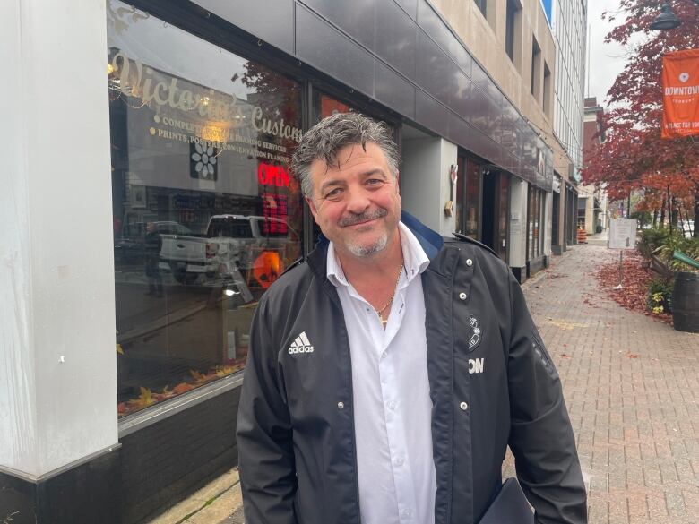 A man wearing a black jacket standing outside.