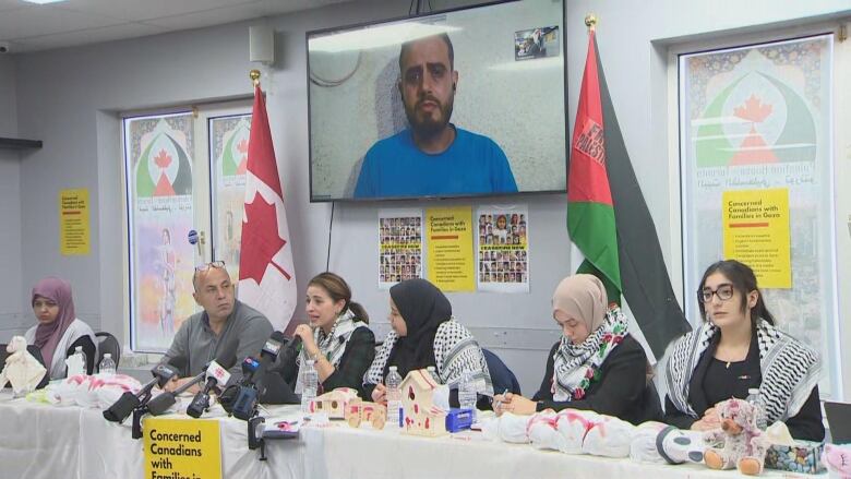 Six people are seated at a table at Palestine House Toronto.