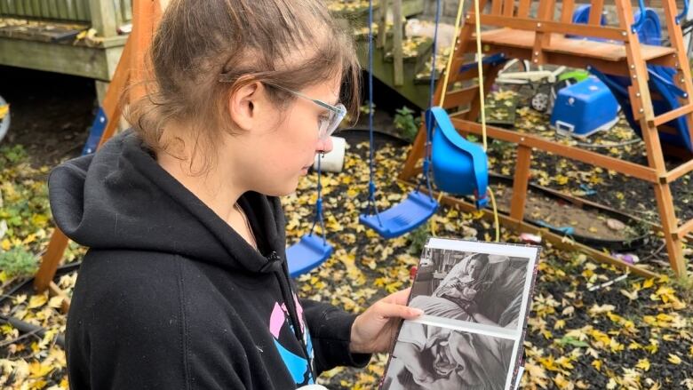 A woman looks at a photo album.