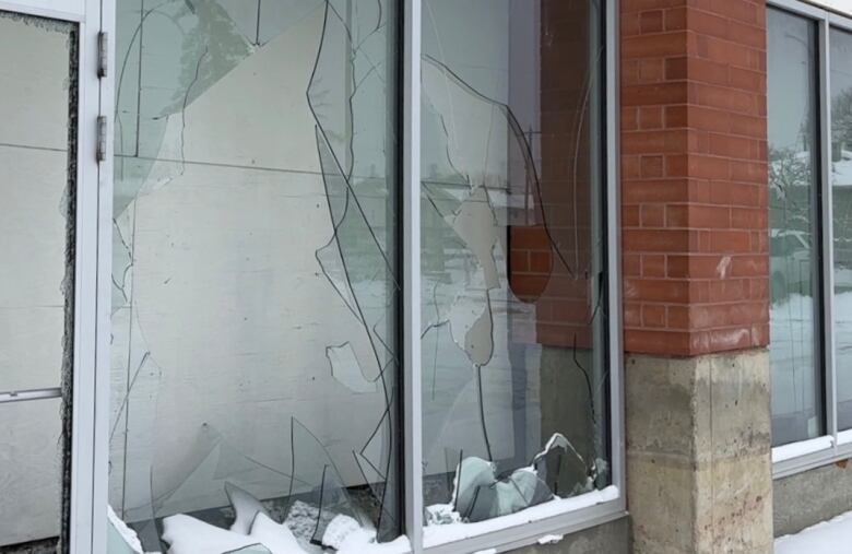 Smashed window panes with broken glass are pictured on the main floor of the building.