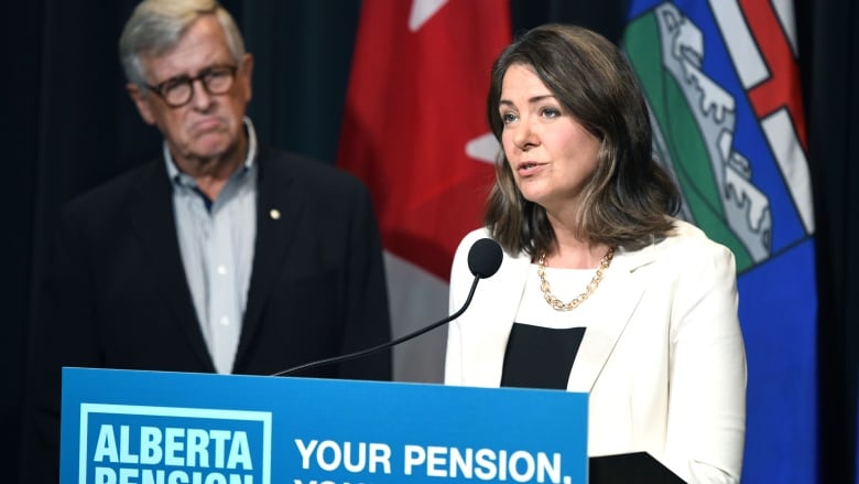 Jim Dinning watches as Premier Danielle Smith speaks at the Sept. 21 release of a report about an Alberta pension plan. Dinning, a former provincial finance minister, heads an engagement panel that will hold a series of telephone town halls across Alberta to gauge support for the proposed plan.