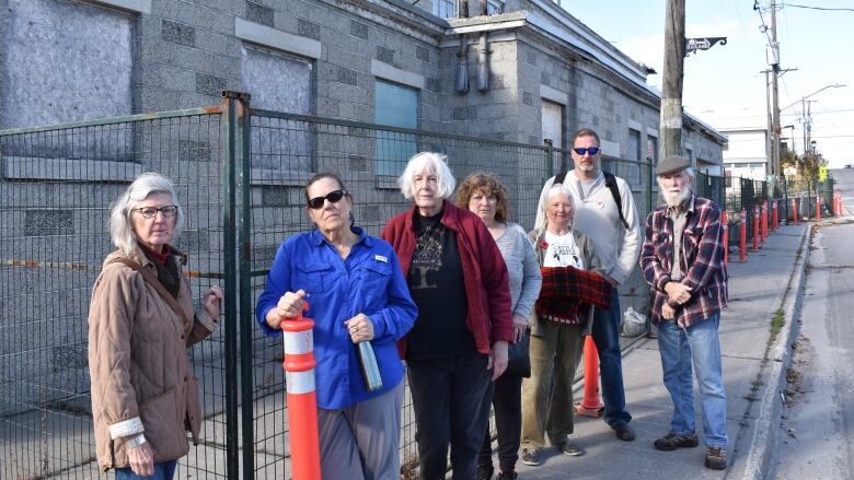 People stand outside an old building.