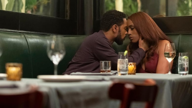 LaKeith Stanfield (left) and Issa Rae (right) sitting in a restaurant booth in the film The Photograph. They're leaning into one another, foreheads touching. 