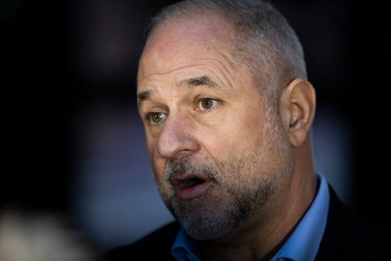 Portrait of a white man with a salt-and-pepper stubble.