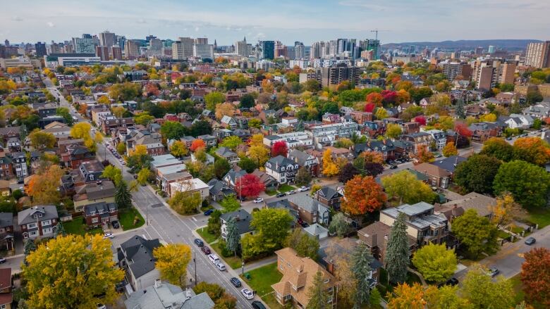 A residential part of a city's downtown in autumn. The taller buildings of the core are in the background.