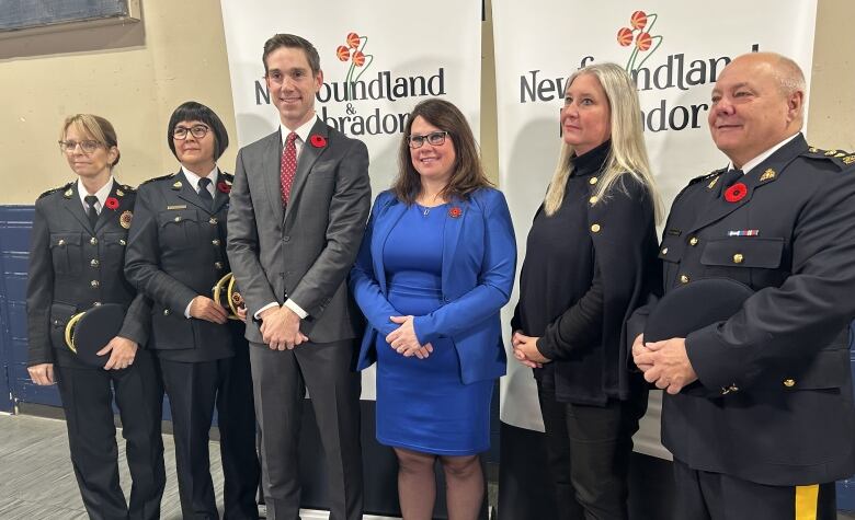 A group of people standing in a line. A backdrop behind them reads Newfoundland and Labrador.