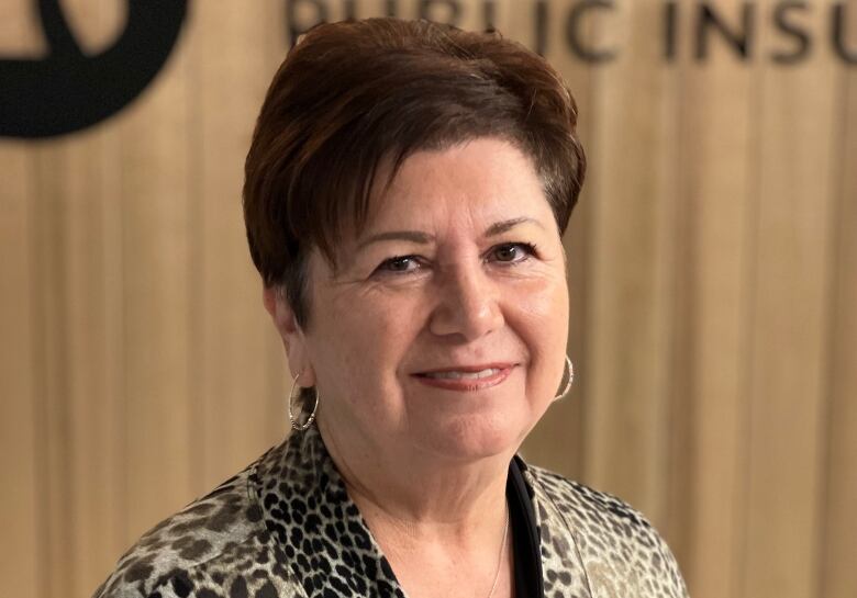 A woman with short hair wearing an animal print shirt