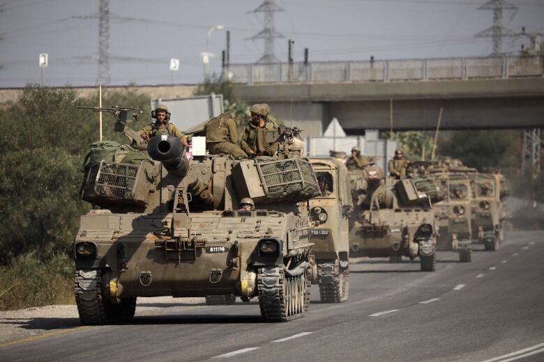 A group of Israeli military vehicles travel down a highway in Sderot, Israel.