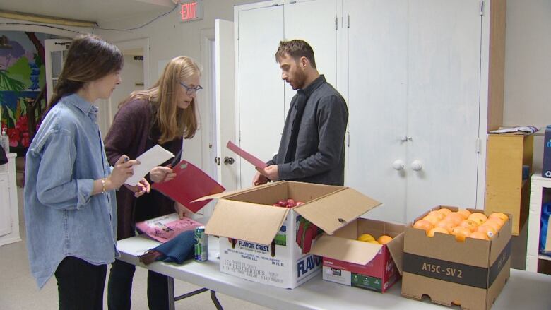 People standing around boxes of food.