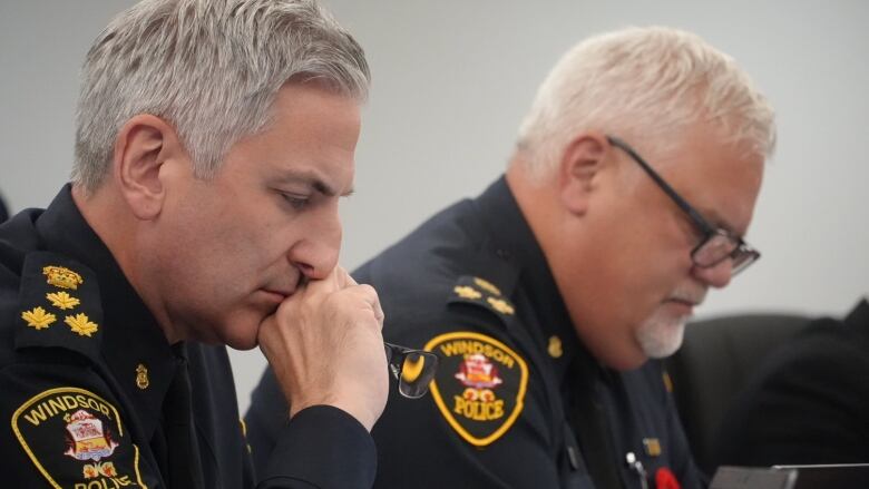 Two men sits at a table in police uniforms