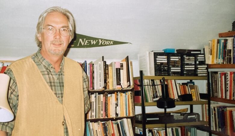 A man in an office of books.