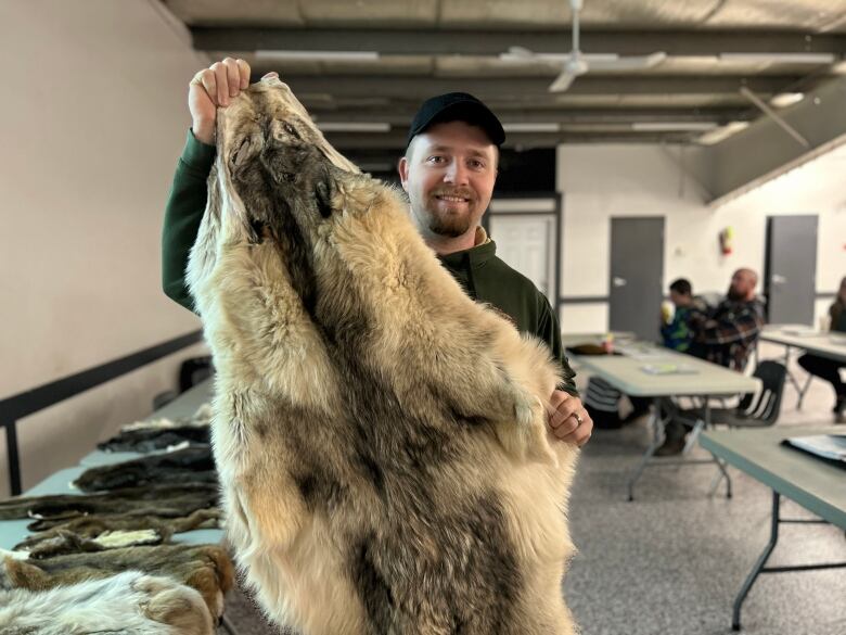 A man holding up fur. 