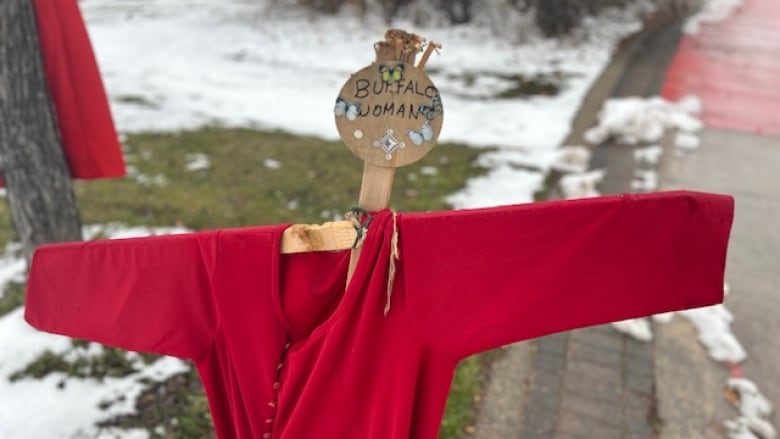 The name Buffalo Woman marks a piece of wood that holds a red dress near the Canadian Museum for Human Rights. 