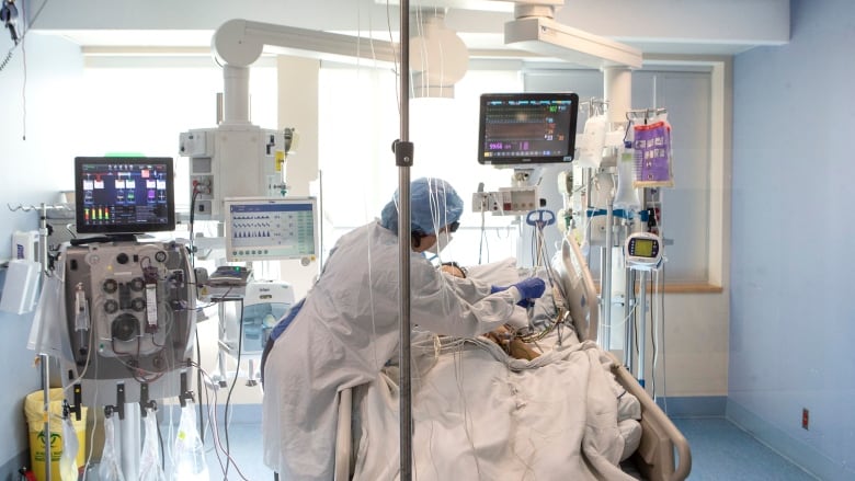 A nurse tends to a patient in hospital. 