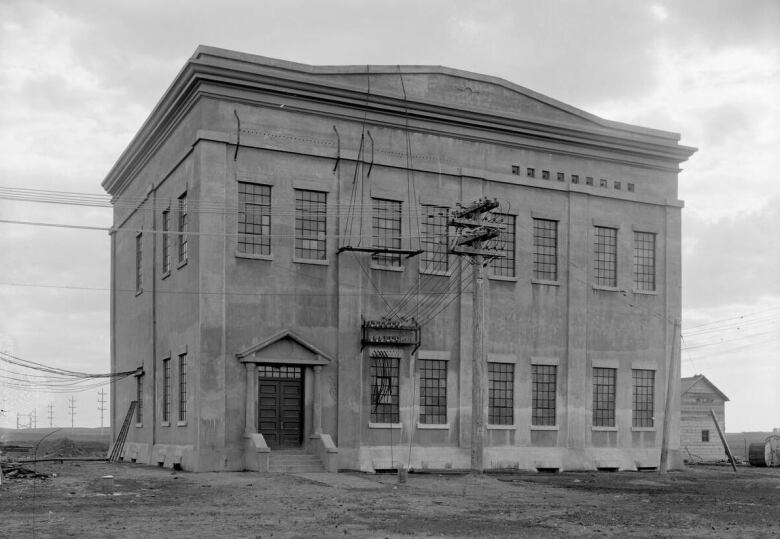 An old two story building in a black and white picture. 