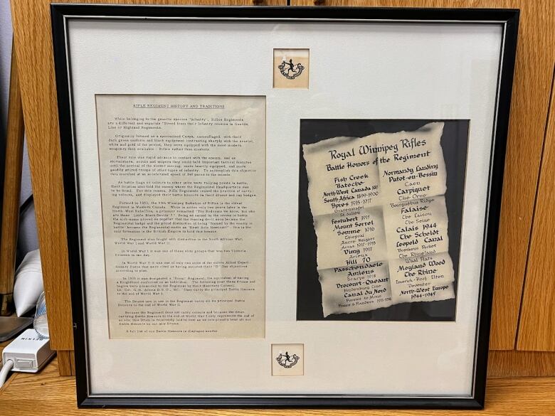 A picture frame with documents surrounded by matting.