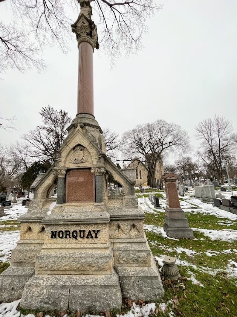 A large stone grave marker with the name Norquay on it.