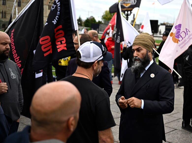 NDP Leader Jagmeet Singh speaks with longshore workers from the Port de Quebec, who have been locked out for a year, during a rally for federal anti-scab legislation on Parliament Hill in Ottawa, on Tuesday, Sept. 19, 2023. THE CANADIAN PRESS/Justin Tang