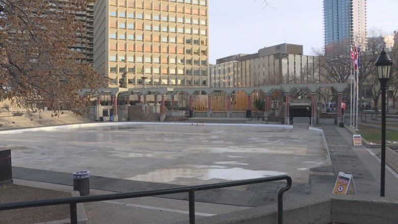 a plaza with grey concrete and brick pillars 