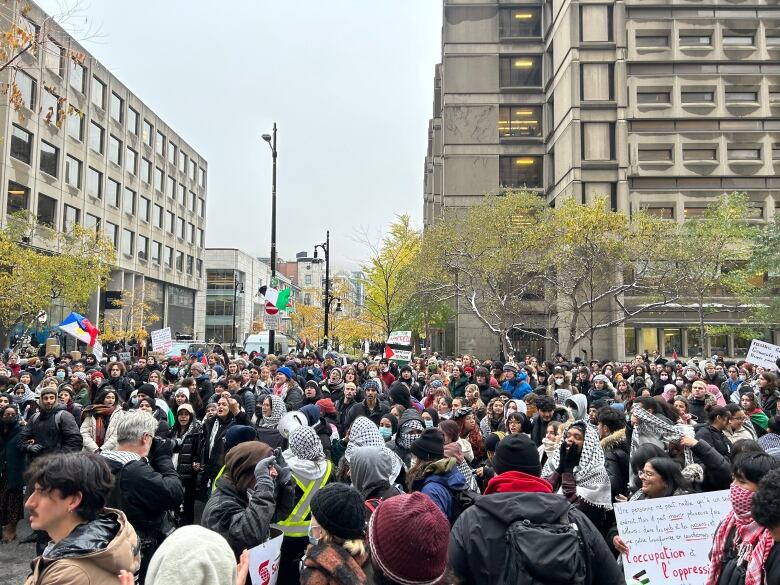 People stand in the street with signs.