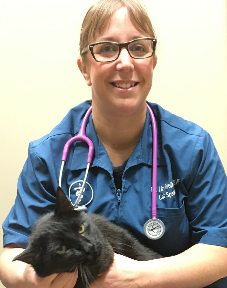 A woman holds a cat. 