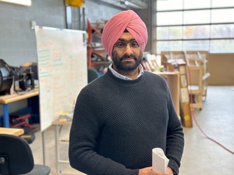 A man in a turban stands in a lab 