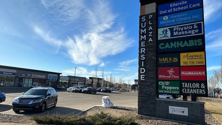 A strip mall sign is shown on a sunny day.