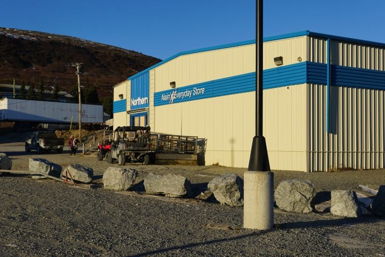 A blue and white building surrounded by large rocks. 