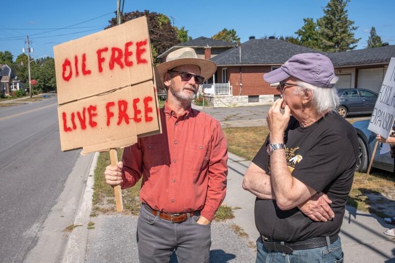 Climate protesters hold a sign at the roadside.