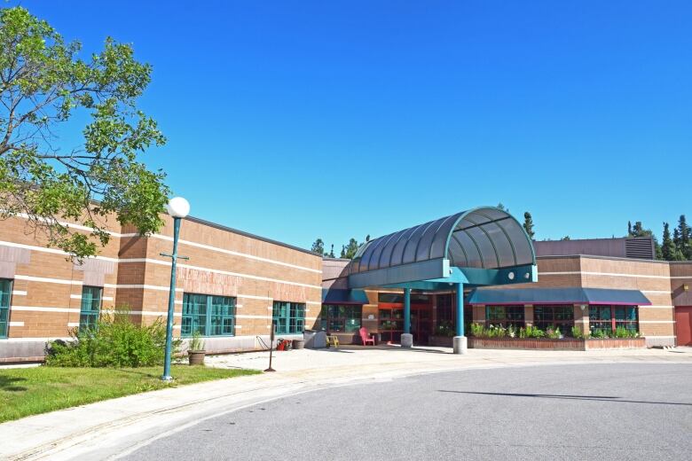 A reddish-brick building beneath a blue sky.