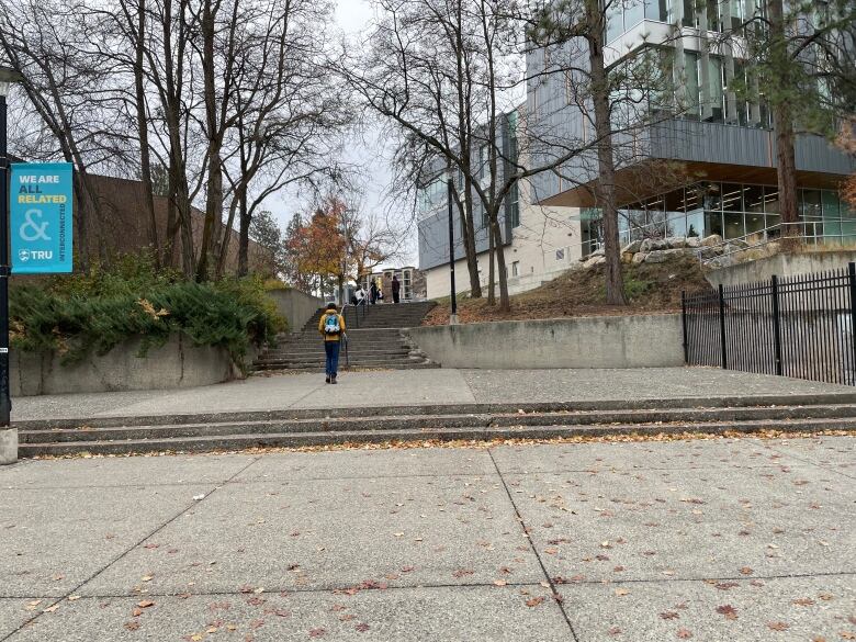 People in the distance going up a staircase at a University campus.