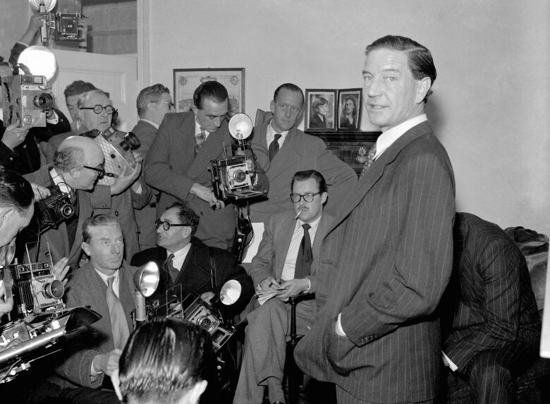 In this file photo dated Nov. 8, 1955, former British diplomat who was at that time accused of spying for Russia, during a press conference at his parents' home in London on Nov. 8, 1955.  In a 1981 film posted online Monday April 4, 2016, by the BBC, notorious British spy Kim Philby is shown in newly uncovered footage addressing East German spies, 