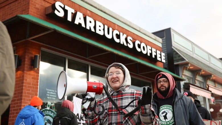 Workers protest outside a Starbucks location on Red Cup Day last year.