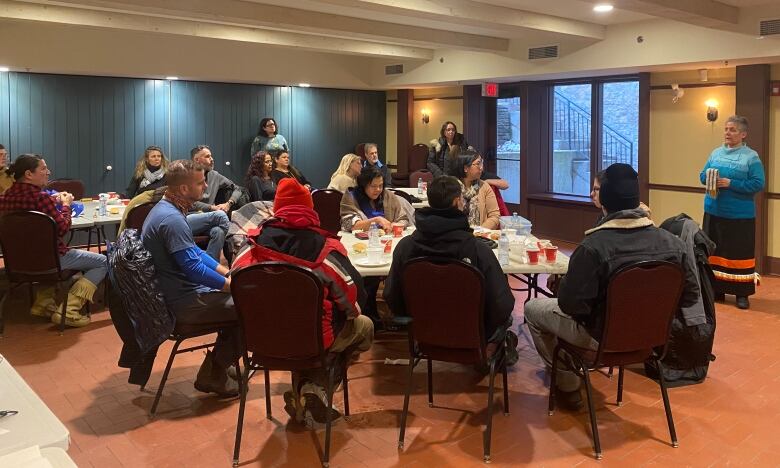 Groups of people sit around tables.