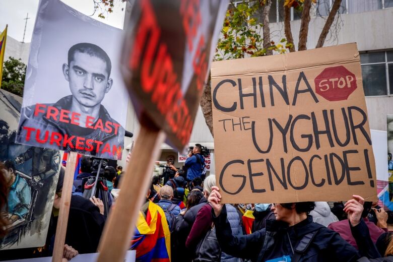 Protesters hold signs like, 