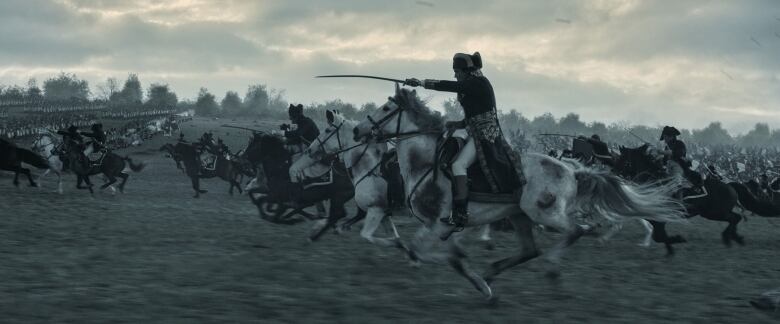 A cavalry regiment charges into battle. The closest figure holds a sword in front of them. 