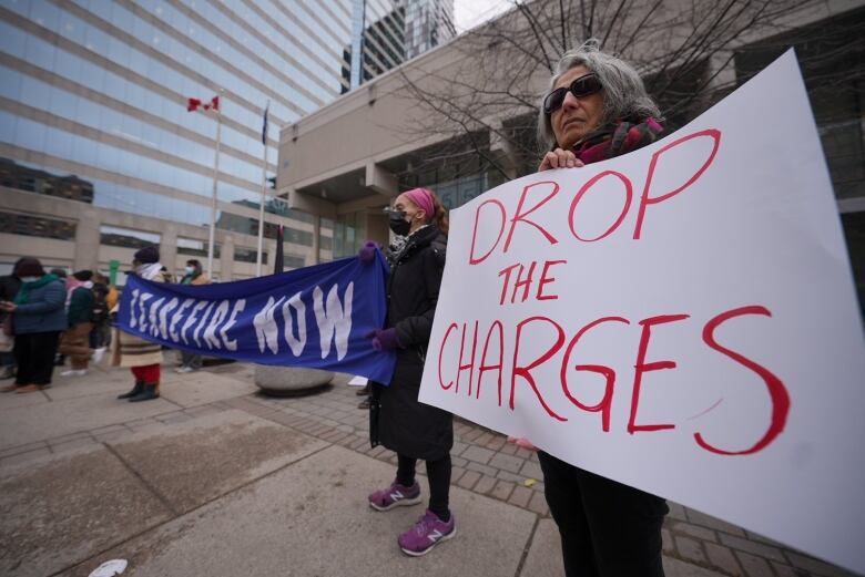 A woman holds a sign that reads 