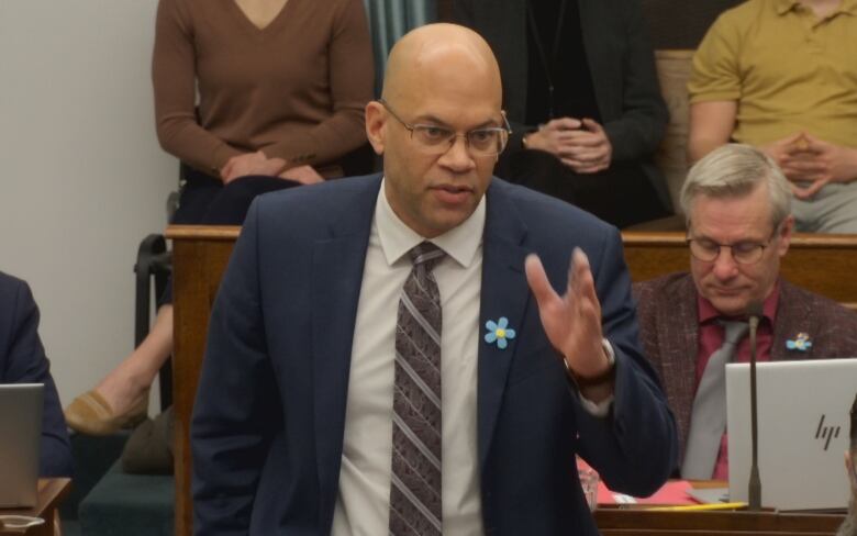 A PEI MLA stands in the legislative assembly asking a question to government.