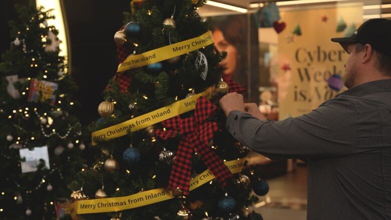 An employee from Inland Truck and Equipment decorates a tree sponsored by his company as a part of the Festival of Trees.