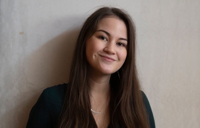 A portrait shows a young woman with long dark hair smiling at the camera.