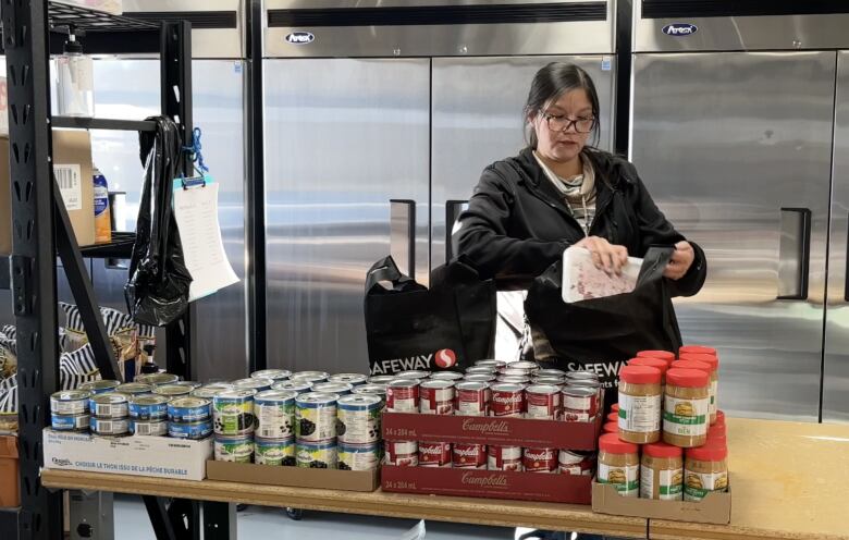 A woman makes a food hamper.