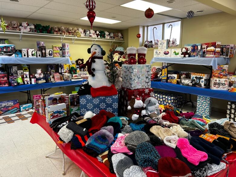 A room is full of toys, stuffed animals and knitted hats and mittens.