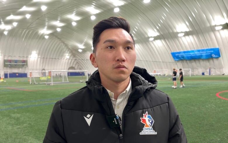 Richard Ha stands in a soccer centre.